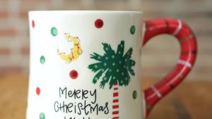 Ceramic Mug with Green and Red multi colored Palmetto Tree, Yellow Crescent, Red Striped Handle and the words Merry Christmas Y All