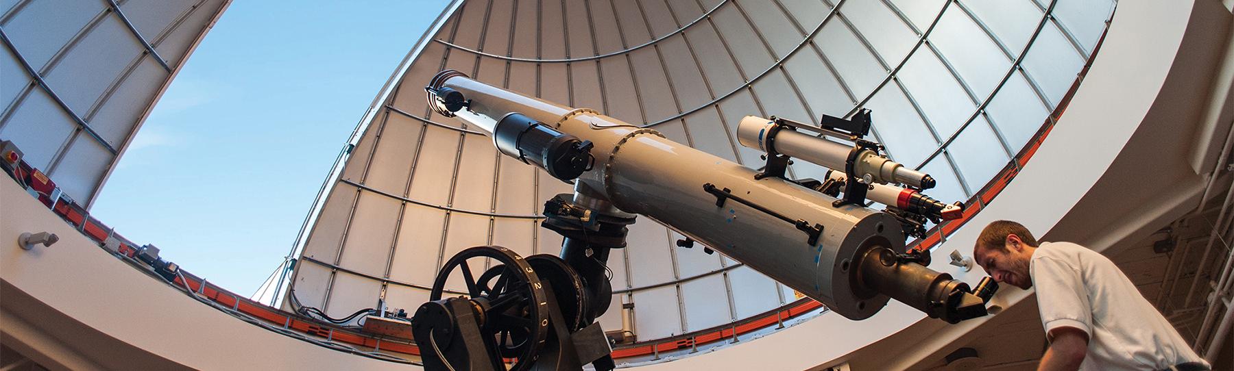Observatory Educator Looks Through Alvan Clark Telescope During Solar Observing Hours With Dome Open Above Him Showing Blue Sky