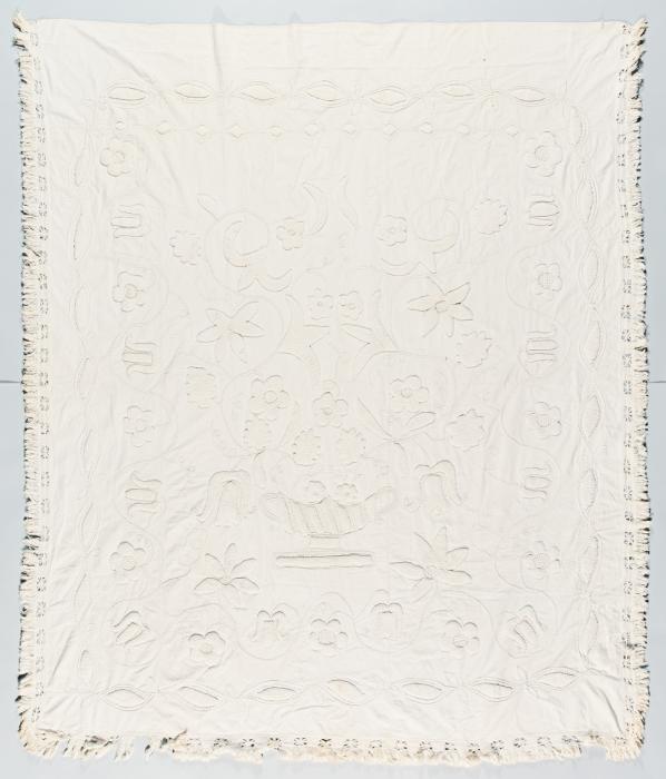 Whitework coverlet with flower designs throughout