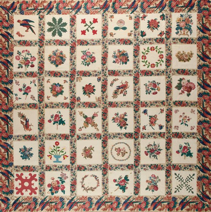 Quilt with floral chintz border made of rows on 6 squares across featuring individual motifs of flowers, planets and even one bird in the top most upper left square. Colors are mostly pinks, greens, blues and yellows.